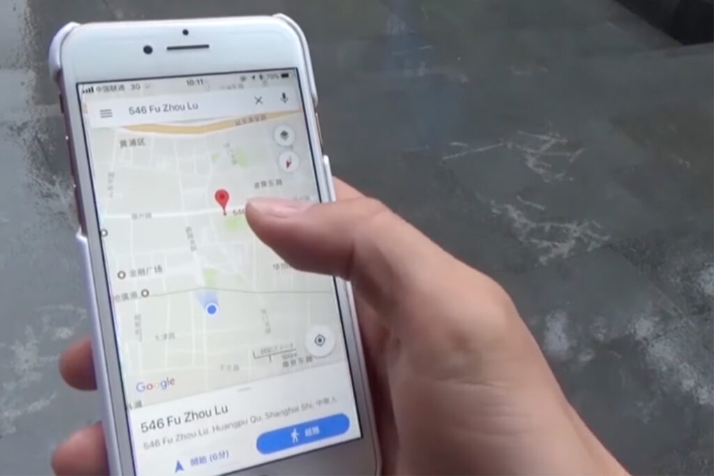 A hand holding a smartphone showing a map app