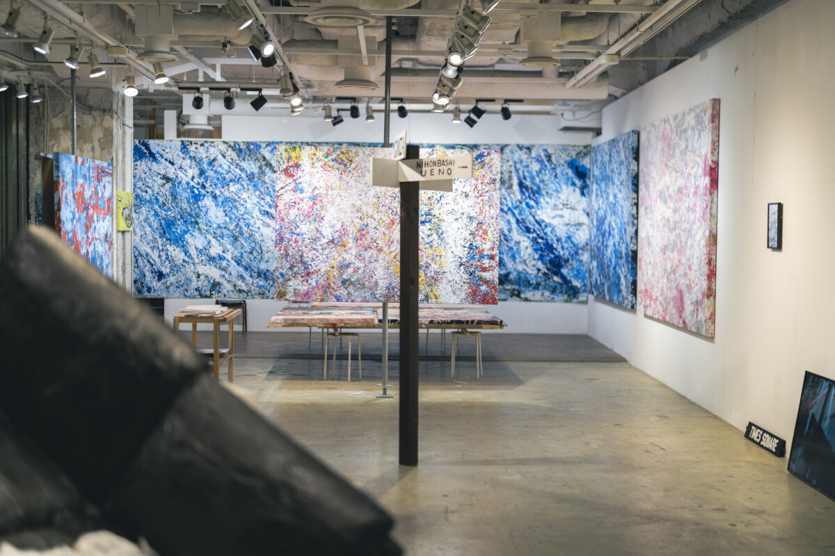 Interior of ON LIMITS — a wall-sized blue painting and a tubular object lying in the foreground (Sonoaida #Shin-Yurakucho, Tokyo)