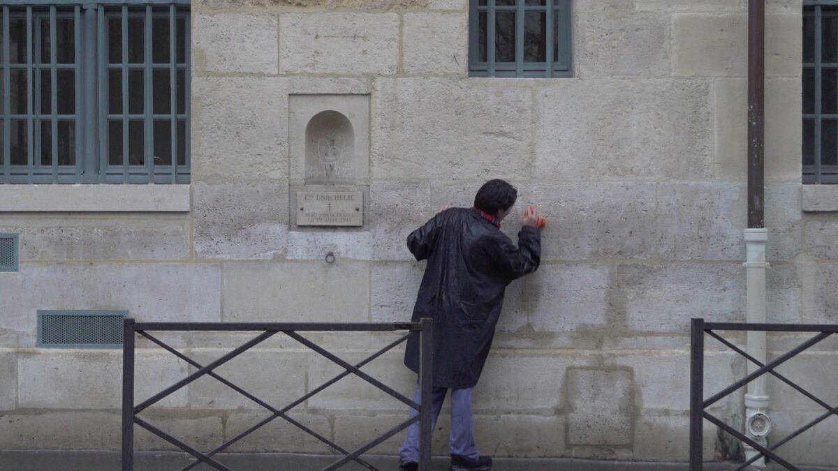 Demonstration for becoming a “professional unemployed” – the artist leaning against the wall while wiping it with a cloth, Rue de Seine, Paris