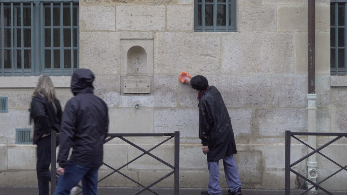 Demonstration for becoming a “professional unemployed” – the artist keeps wiping the wall as two passersby walk by, Rue de Seine, Paris